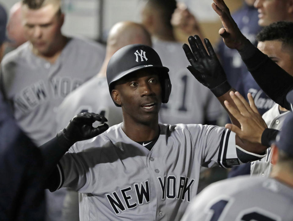 FILE - In this Sept. 7, 2018, file photo, New York Yankees' Andrew McCutchen is greeted in the dugout after he hit a two-run home run during the third inning of a baseball game against the Seattle Mariners, in Seattle. A person familiar with the negotiations tells The Associated Press that All-Star outfielder Andrew McCutchen and the Philadelphia Phillies have agreed to a $50 million three-year contract. The person spoke on condition of anonymity Tuesday, Dec. 11, 2018, because the agreement, which includes a club option for 2022, is subject to a successful physical.(AP Photo/Ted S. Warren, File)