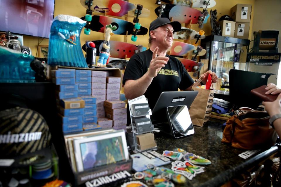 A man stands behind the counter of a store