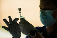 FILE - In this Sept. 14, 2021 file photo, a syringe is prepared with the Pfizer COVID-19 vaccine at a clinic at the Reading Area Community College in Reading, Pa. Businesses that have announced vaccine mandates say some workers who had been on the fence have since gotten inoculated against COVID-19. But many holdouts remain — a likely sign of what is to come once a federal mandate goes into effect. (AP Photo/Matt Rourke, File)