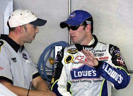 NASCAR points leader Jimmie Johnson talks with his crew chief Chad Knaus (left) in the garage of the Indianapolis Motor Speedway in Indianapolis on Friday.  AJ Mast |  Associated Press
