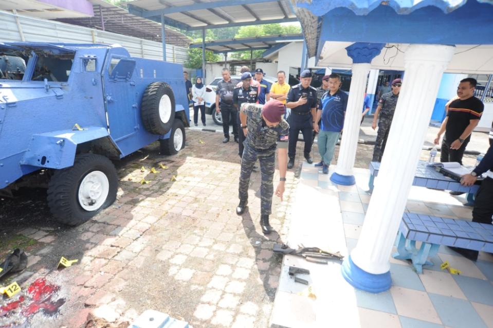 Inspector-General of Police Tan Sri Razarudin Husain examines the scene of an attack at the Ulu Tiram police station near Johor Baru on May 17, 2024. — Picture by Ben Tan