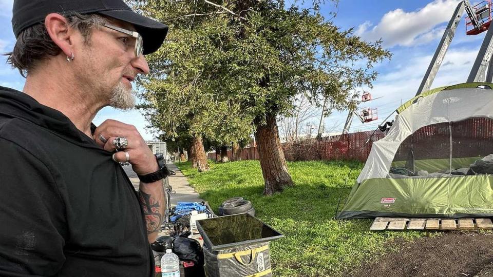 Samuel Buckles prepares to pack his tent and belongings on a recent rainy day in February after code enforcement officials told him to leave the private property where he was camping. His RV had been confiscated just days earlier in a homeless sweep. Angela Hart/KFF Health News