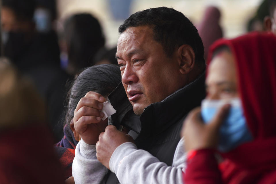 A man cries as he waits to receive the body of a victim of a plane crash, at a hospital in Pokhara, Nepal, Monday, Jan 16, 2023. Nepal began a national day of mourning Monday as rescue workers resumed the search for six missing people a day after a plane to a tourist town crashed into a gorge while attempting to land at a newly opened airport, killing at least 66 of the 72 people aboard in the country's deadliest airplane accident in three decades. (AP Photo/Yunish Gurung)