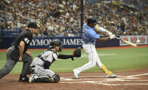 Home plate umpire Jeff Nelson (45) and Miami Marlins catcher Alex Jackson, center, look on as Tampa Bay Rays' Wander Franco (5) hits a double during the first inning of a baseball game Sunday, Sept. 26, 2021, in St. Petersburg, Fla. Franco extended his on-base consecutive game streak to 41. (AP Photo/Steve Nesius)