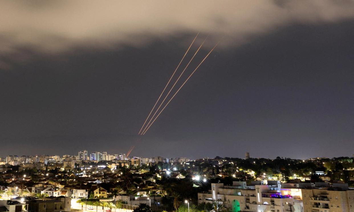 <span>An anti-missile system operates against Iranian-launched drones and missiles on Saturday night in Ashkelon, Israel.</span><span>Photograph: Amir Cohen/Reuters</span>