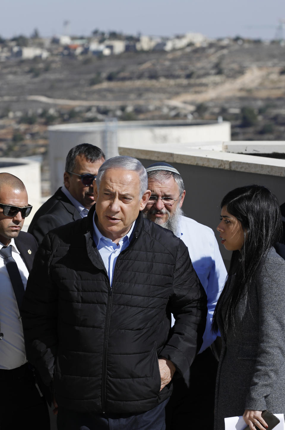 Israeli Prime Minister Benjamin Netanyahu, center, and heads of Israeli settlement authorities tour the Alon Shvut settlement, in the Gush Etzion block, in the occupied the West Bank, Tuesday, Nov. 19, 2019. Netanyahu traveled to the West Bank to celebrate the U.S.’s announcement that it does not consider Israeli settlements to be a violation of international law. (Menahem Kahana/Pool via AP)