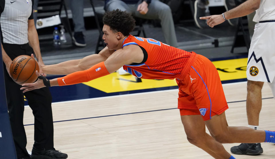 Oklahoma City Thunder forward Isaiah Roby reaches out to pull in a loose ball against the Denver Nuggets in the first half of an NBA basketball game Tuesday, Jan. 19, 2021, in Denver. (AP Photo/David Zalubowski)