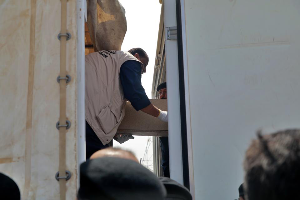 A casket holding the remains of one of 48 Kuwaiti citizens is transferred from an Iraqi truck to a Kuwaiti truck during a handover ceremony at the Safwan border crossing, in Iraq, Thursday, Aug. 8, 2019. Iraqi and Kuwaiti state media said Iraq has handed over to Kuwait the remains of 48 Kuwaitis who went missing during the 1991 Gulf War. (AP Photo)