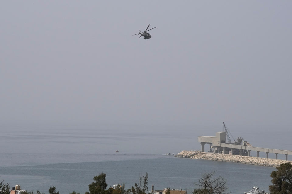 A Lebanese army helicopter takes part in the search of missing people from last week sinking migrant boat, near Tripoli, Lebanon, Wednesday, April 27, 2022. A week ago, a boat carrying around 60 Lebanese trying to escape their country and reach Europe sank in the Mediterranean after colliding with a Navy ship. At least seven people are known dead and at least six are missing. The tragedy underscored the desperation among many Lebanese after the collapse of their country's economy.(AP Photo/Hassan Ammar)