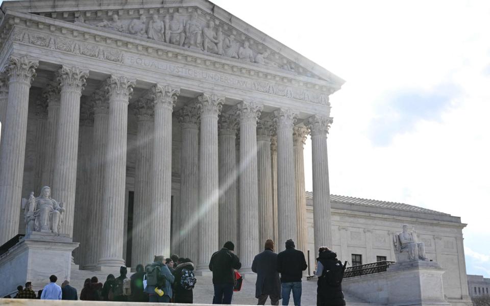 People wait in line outside the US Supreme Court in Washington, DC on February 21, 2023 as the justices hear arguments in two cases that test Section 230, the law that provides tech companies a legal shield over what their users post online. (Photo by Jim WATSON / AFP) (Photo by JIM WATSON/AFP via Getty Images) - JIM WATSON/AFP via Getty Images