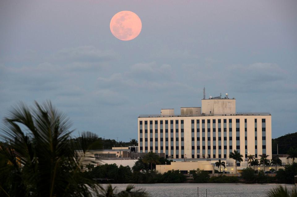 As the sun sets over the St. Lucie River, April's full moon, the brightest supermoon of the year, rises in the east over Cleveland Clinic Martin North Hospital on Tuesday, April 7, 2020, in Stuart, Fla. The hospital is a drive-thru testing site for COVID-19, the virus that has caused a global pandemic and forced millions of Americans to stay home. As of April 7, more than a dozen patients infected with the coronavirus were being treated by Cleveland Clinic in Martin County.