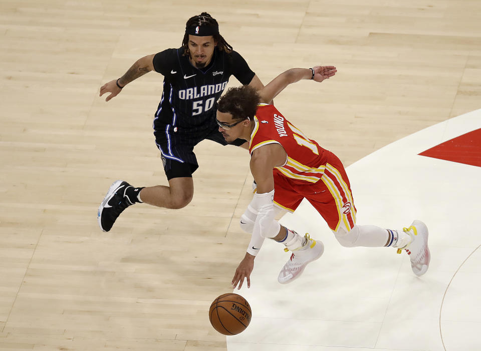 Atlanta Hawks' Trae Young, right, drives the ball past Orlando Magic guard Cole Anthony (50) during the second half of an NBA basketball game Tuesday, April 20, 2021, in Atlanta. (AP Photo/Ben Margot)