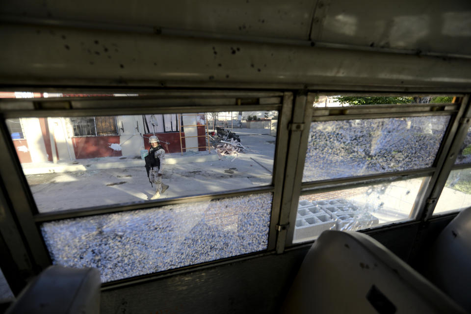 A soldier walks past City Hall that is riddled with bullet holes after a weekend gun battle, in Villa Union, Mexico, Tuesday, Dec. 3, 2019. Villa Union residents said Tuesday they fear a return to the bad old days of 2010-2013. The small town is 12 miles (20 kilometers) from the town of Allende, the site of a 2011 massacre in which the Zetas killed at least 70 people. (AP Photo/Eduardo Verdugo)