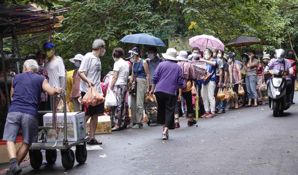 國內今(22)日新增30例本土病例，其中雙北就佔了22例，眼看7月26日可能解封在即，但今天本土病例卻又突然增加，有網友忍不住道出南部人心聲。圖為21日北市信義區一處登山步道，民眾攤搶購量販式水果，大排長龍。(黃子明攝)