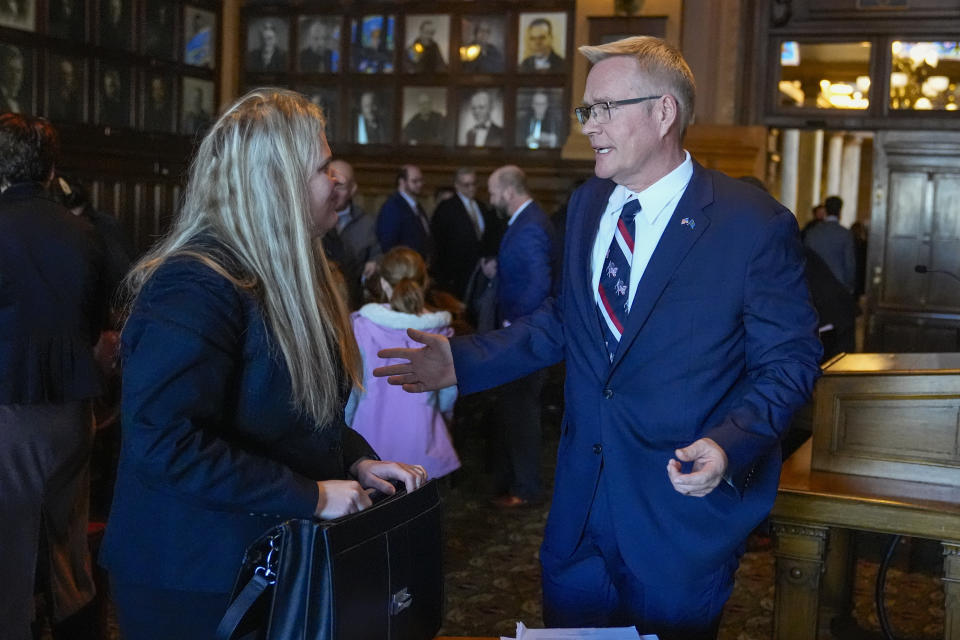 Plaintiff John Rust speaks with his attorney Michelle Harter following oral arguments before the Indiana Supreme Court at the Statehouse in Indianapolis, Monday, Feb. 12, 2024. GOP Senate candidate, John Rust, who is suing to appear on the primary ballot. A trial judge ruled in December that a state law that stipulates candidates must vote in two primary elections with their party is unconstitutional. The state appealed the ruling. (AP Photo/Michael Conroy, Pool)