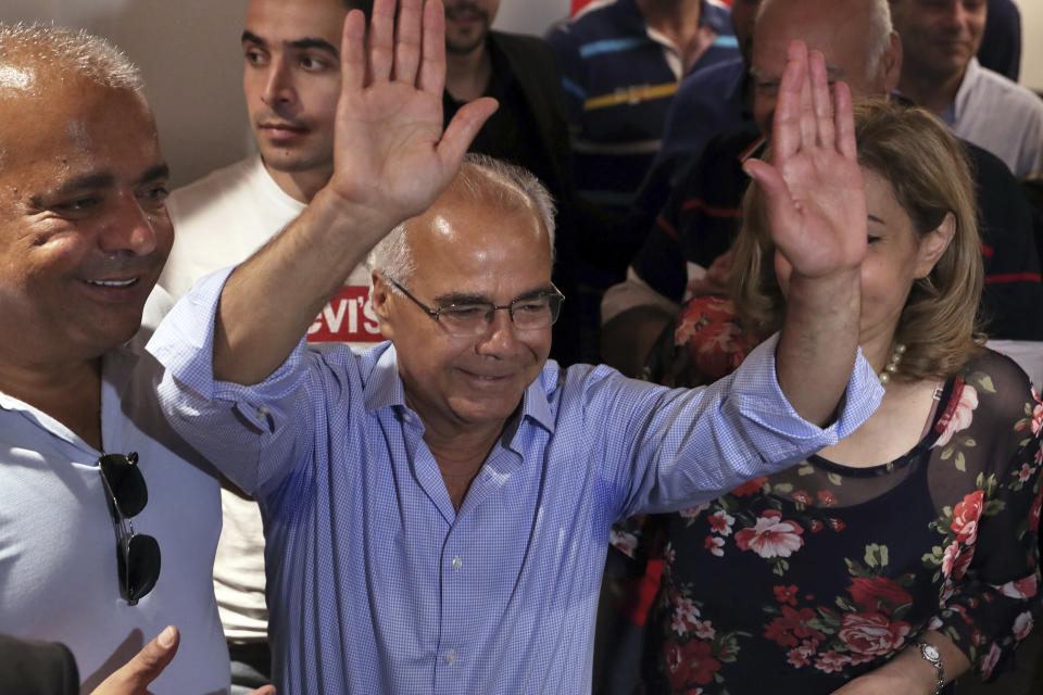 Mohammed Saleh who was detained in Greece last week, raises his hands upon his arrival at the Rafik Hariri International Airport in Beirut, Lebanon, Wednesday, Sept. 25, 2019. Saleh, a Lebanese journalist was mistakenly detained in Greece on suspicion of involvement in a 1985 TWA hijacking has arrived home in Lebanon. (AP Photo/Bilal Hussein)