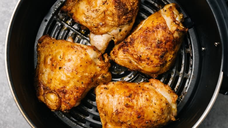 Top-down view of chicken thighs in an air fryer