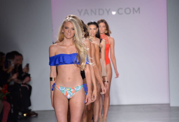 A handful of models in a line wear swimsuits on the runway at the Yandy NYFW event.