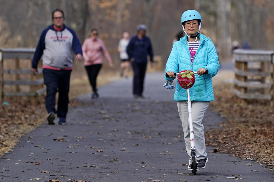 People walk and ride along a trail.