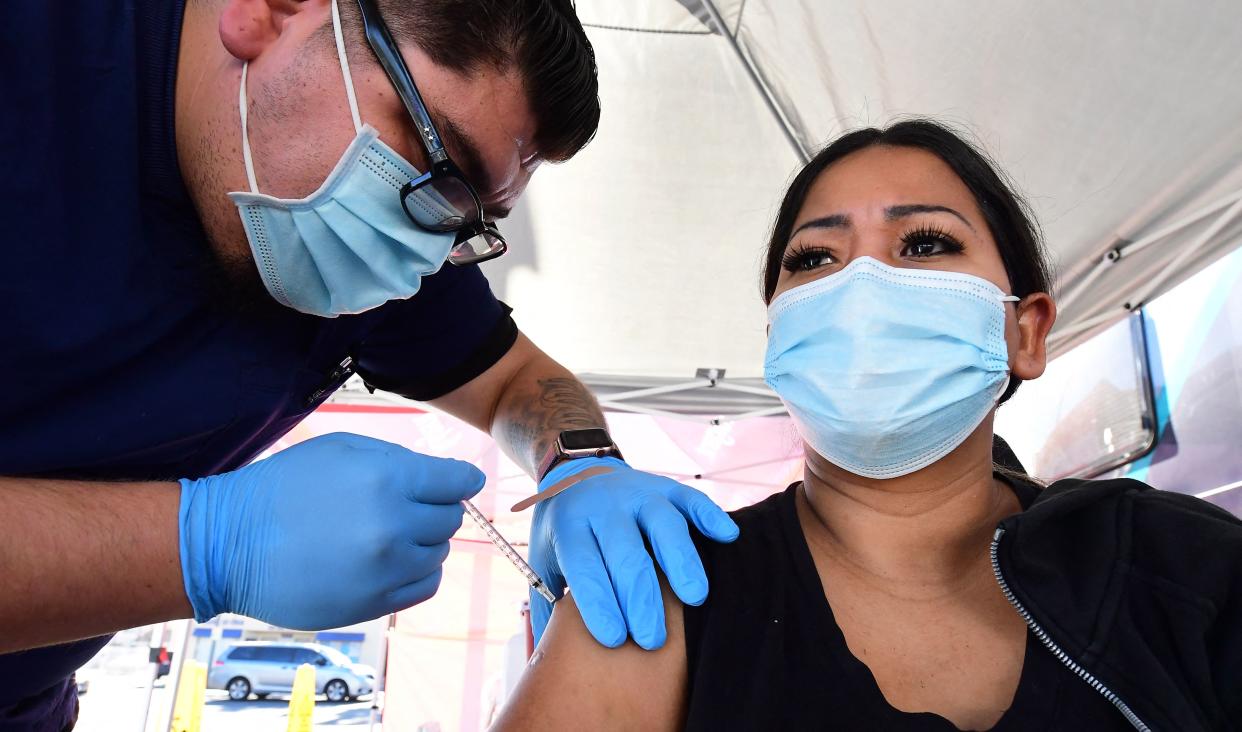 Carmen Penaloza receives her first dose of the Pfizer COVID-19 vaccine 