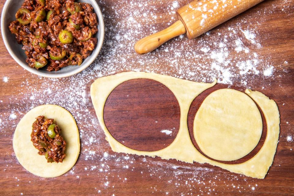 The making of Picadillo Empanadas; rolling and filling dough.