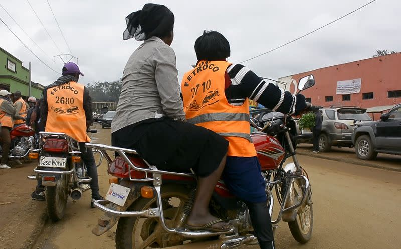 Congolese motorbike taxi rider Imelda Mmambu carries a client on her motorbike along the streets of Beni