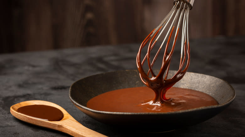 Ganache in bowl with whisk and spoon