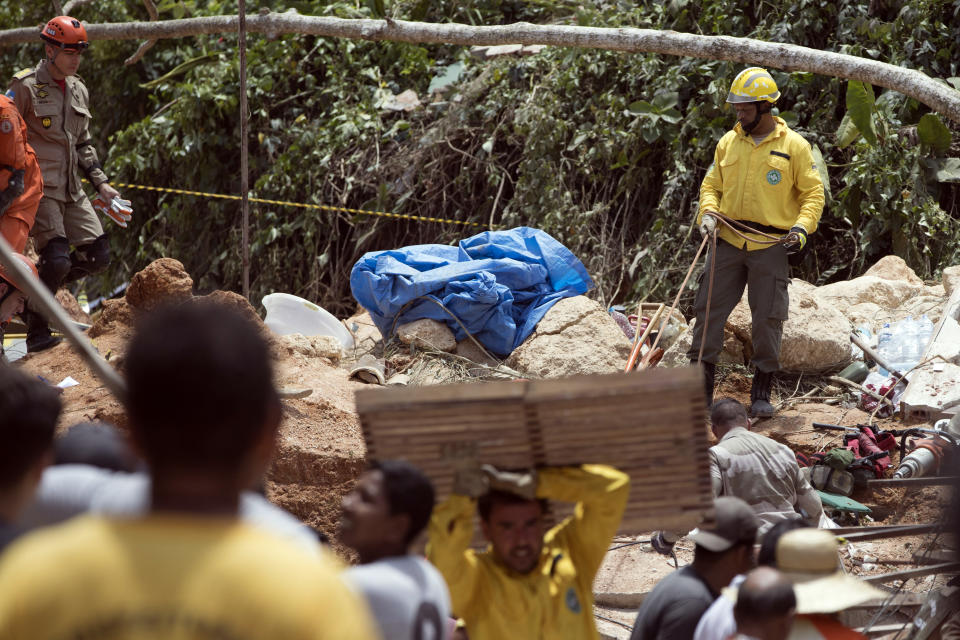 A firefighter works on the debris after a mudslide in Boa Esperanca or "Good Hope" shantytown in Niteroi, Brazil, Saturday, Nov. 10, 2018. Several people were killed and others injured in a mudslide near Rio de Janeiro on Saturday, Brazilian authorities said. (AP Photo/Leo Correa)