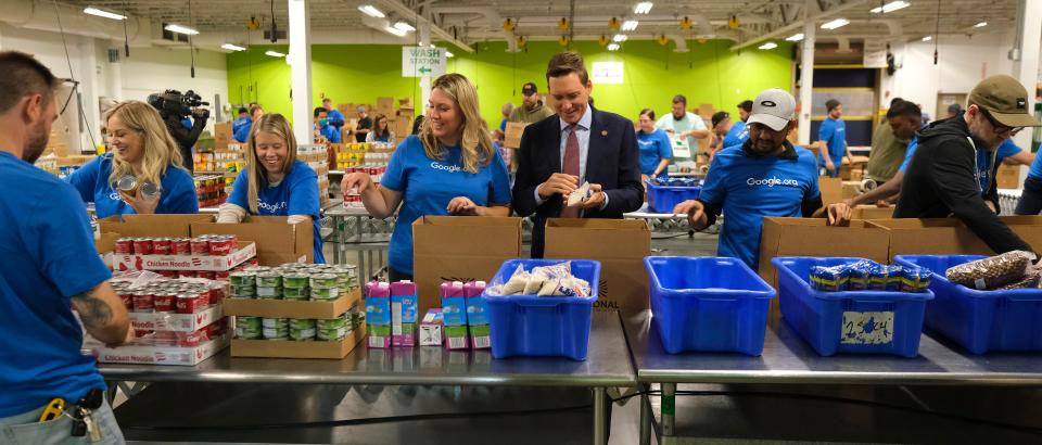 Lt. Gov. Matt Pinnell boxes food with Google volunteers at the Regional Food Bank of Oklahoma Volunteer Center on Monday.