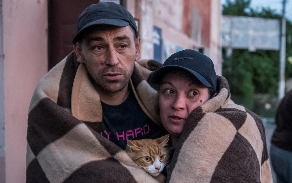 Local residents cling to their cat after they were evacuated from a flood zone - STRINGER