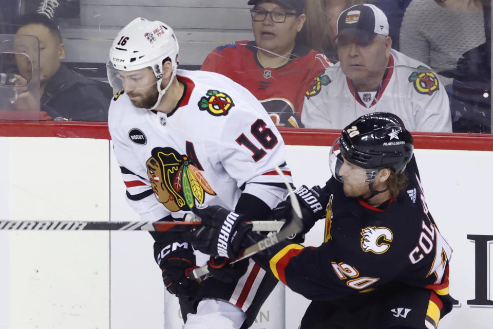 Chicago Blackhawks' Jason Dickinson, left, works against Calgary Flames' Blake Coleman during the first period of an NHL hockey game Saturday, Jan. 27, 2024, in Calgary, Alberta. (Larry MacDougal/The Canadian Press via AP)