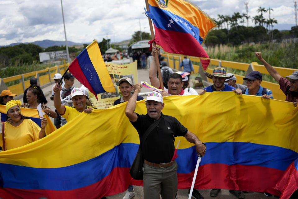 Partidarios del nuevo presidente de Colombia, Gustavo Petro, ondean banderas de Colombia y Venezuela en San Antonio, en la frontera venezolana con Colombia, el domingo 7 de agosto de 2022. (AP Foto/Matias Delacroix)