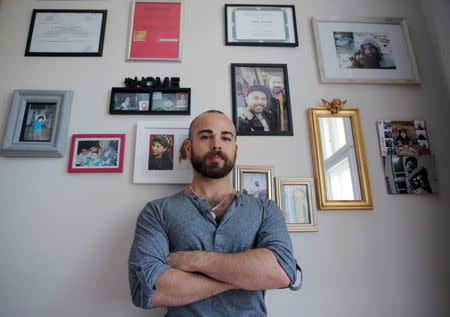 Syrian migrant Haidar Darwish stands in front of a wall covered with memories in his room in Berlin, Germany, July 13, 2018. REUTERS/Alessia Cocca