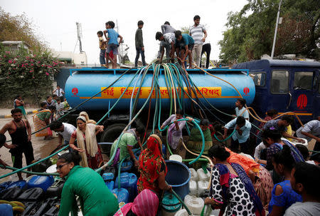 Residents fill their containers with drinking water from a municipal tanker in New Delhi, India, June 26, 2018. REUTERS/Adnan Abidi