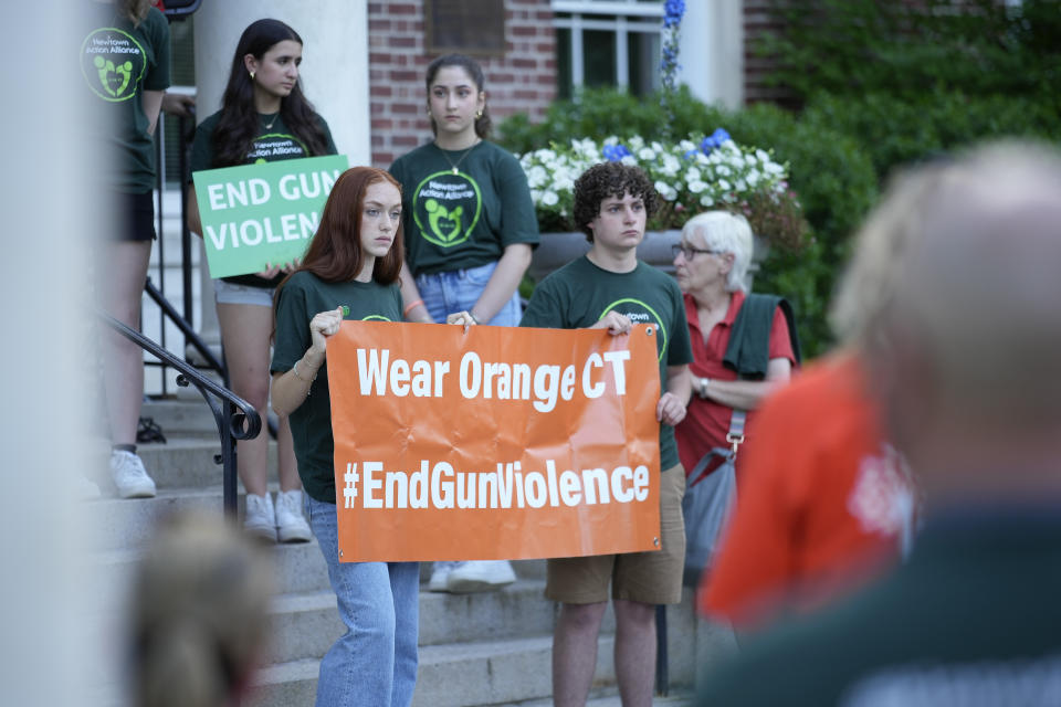 Members of Junior Newtown Action Alliance hold signs during a rally against gun violence on Friday, June 7, 2024 in Newtown, Conn. (AP Photo/Bryan Woolston)