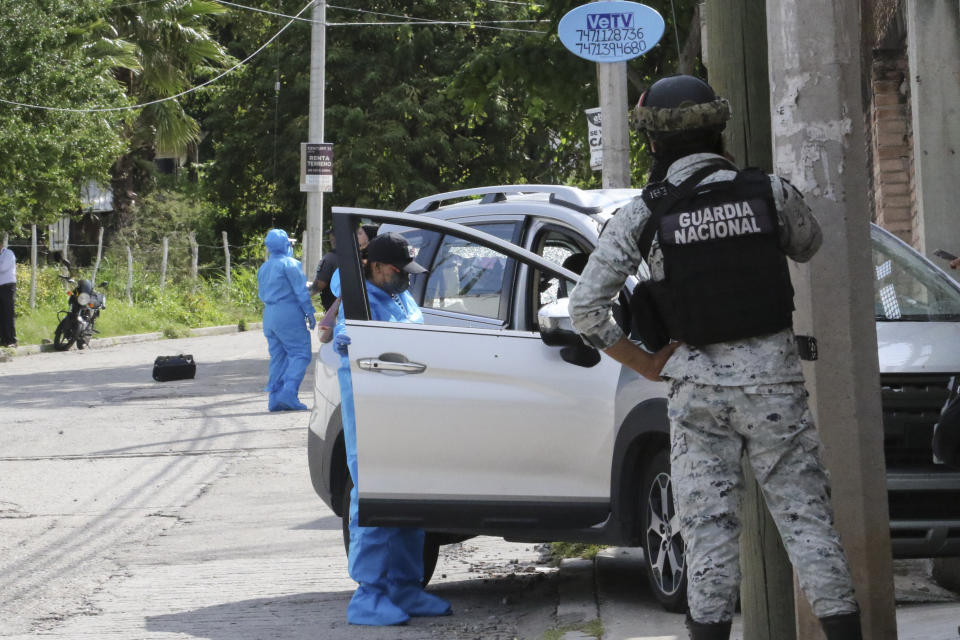 A Mexican National Guardsman looks on as forensic examiners investigate the crime scene where Fernando García Fernández, the representative of Mexico’s Attorney General’s office in the southern state of Guerrero, was gunned down, in Chilpancingo, Mexico, Tuesday, Sept. 12, 2023. (AP Photo/Alejandrino Gonzalez)