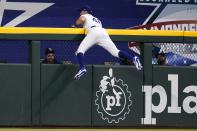 Texas Rangers center fielder Eli White hangs on the center field wall after catching a flyout by Tampa Bay Rays' Ji-Man Choi in the first inning of a baseball game, Monday, May 30, 2022, in Arlington, Texas. (AP Photo/Tony Gutierrez)