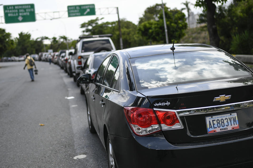 Vehicles wait in line to fill up with fuel at a state oil company PDVSA gas station in Caracas, Venezuela, Tuesday, June 2, 2020. Starting June, Venezuelans pay international market fuel prices, with limited access to subsidized gasoline each month, marking a historic break in the country's practice of having the world's cheapest fuel. (AP Photo/Matias Delacroix)