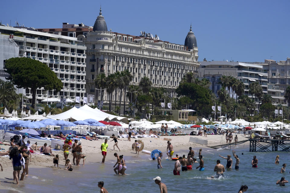 Members of the public take a swim in the sea in front of the Carlton hotel ahead of the 74th international film festival, Cannes, southern France, July 5, 2021. The Cannes film festival runs from July 6 - July 17, 2021. (AP Photo/ Brynn Anderson)