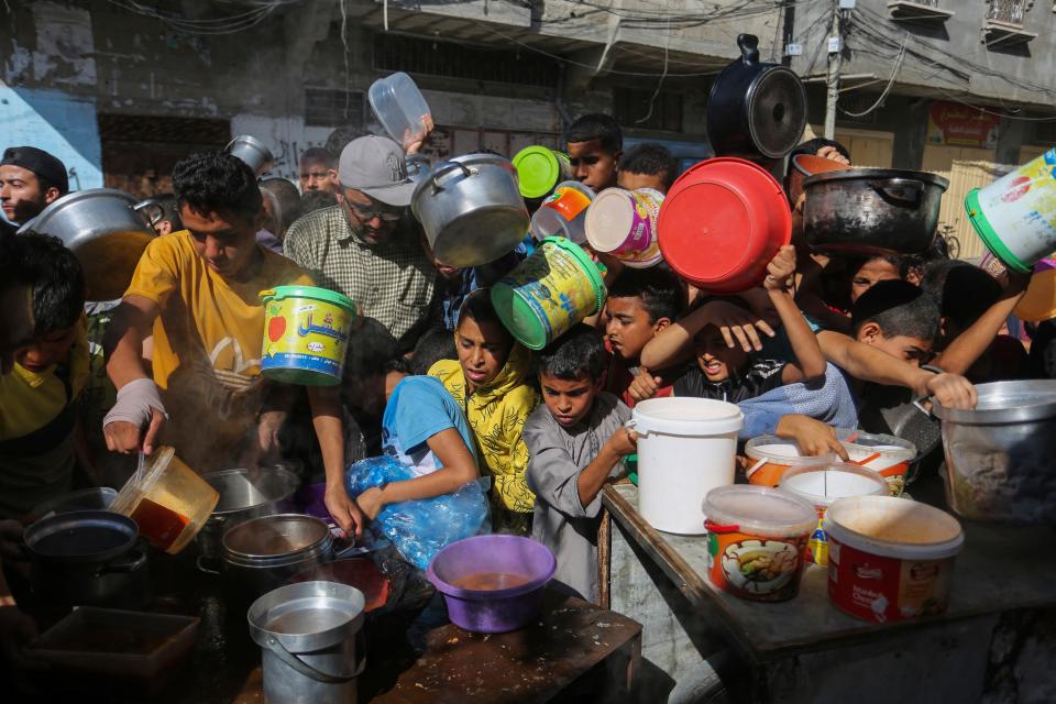 Palestinians crowd together as they wait for food distribution in Rafah, southern Gaza Strip, on Nov. 8, 2023.