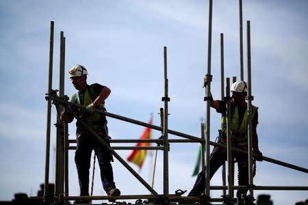 Workers build a pipe structure on a scaffolding in the Andalusian capital of Seville, Spain, April 28, 2016. REUTERS/Marcelo del Pozo/File Photo