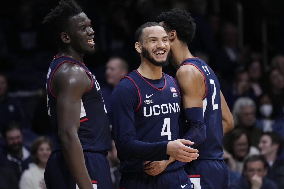 Connecticut guard Tyrese Martin, center, is congratulated by teammates Tyler Polley, right, and Adama Sanogo after being fouled in the second half of an NCAA college basketball game against Butler in Indianapolis, Thursday, Jan. 20, 2022. (AP Photo/AJ Mast)