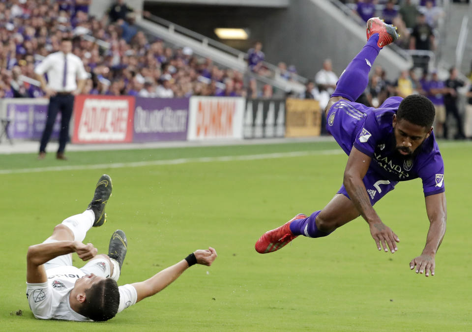 D.C. United's Joseph Mora, left, collides with Orlando City's Ruan, right, while going after the ball during the first half of an MLS soccer match Sunday, March 31, 2019, in Orlando, Fla. Mora was injured in the play and left the match. (AP Photo/John Raoux)