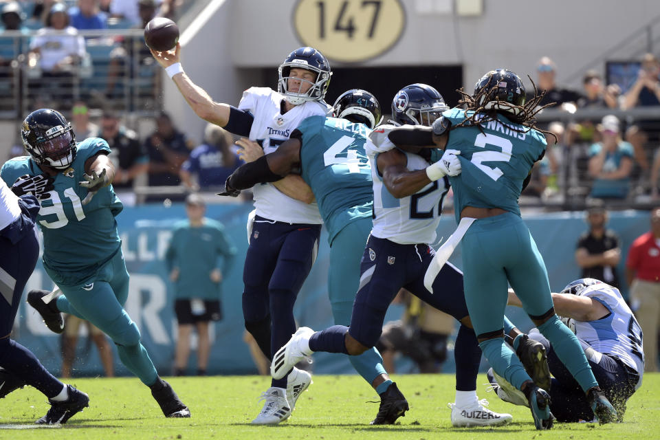 Tennessee Titans quarterback Ryan Tannehill, center, is hit by Jacksonville Jaguars outside linebacker Josh Allen (41) as he releases the ball during the first half of an NFL football game, Sunday, Oct. 10, 2021, in Jacksonville, Fla. (AP Photo/Phelan M. Ebenhack)
