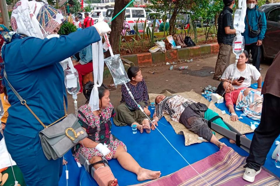 People injured during an earthquake receive medical treatment in a hospital parking lot in Cianjur, West Java, Indonesia (AP)