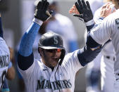 Seattle Mariners' Ty France celebrates in the dugout after hitting a solo home run off of Tampa Bay Rays relief pitcher Ryan Thompson during the seventh inning of a baseball game, Sunday, June 20, 2021, in Seattle. (AP Photo/Stephen Brashear)