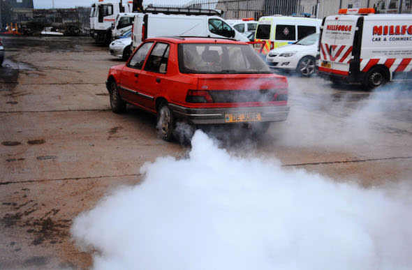 A speeding driver who deployed a James Bond-style smokescreen device in a bid to shake off police has been spared jail.  Simon Chaplin, 62, rigged a bucket of diesel, a pump and pipes, behind the passenger seat of his Peugeot 309 to produce "colossal" amounts of grey smoke from his exhaust.  A court heard "eccentric" Chaplin activated the device when a policeman attempted to pull him over for speeding and covered the carriageway with fumes.  Chaplin tried to evade the officer's flashing blue lights but the policeman was simply able to follow the billowing plumes through country roads near Haverfordwest, Pembs.   Pictured here is the smokescreen in action  Â© WALES NEWS SERVICE   