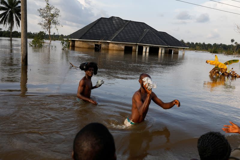 Residents wade through flood water following a massive flood in Obagi community, Rivers state