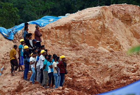 Construction workers are seen at a construction site after it was hit by a landslide in Tanjung Bungah, a suburb of George Town, Penang, Malaysia October 21, 2017. REUTERS/Lai Seng Sin