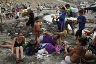 Mientras la elite se aleja de Lima en busca de playas casi solitarias que resguardan con guardias privados y cercas, la clase obrera arriba por millares a una curva franja costera de arenas pardas y suave oleaje. (AP Photo/Rodrigo Abd)